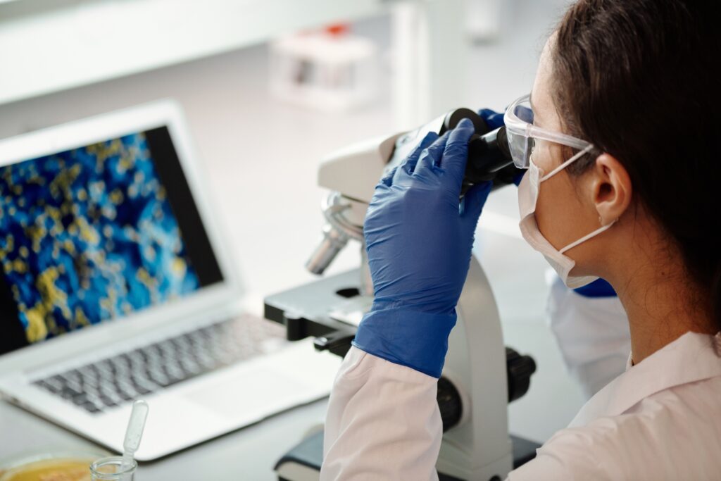Woman scientist examines microscope